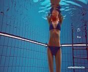Redhead in blue bikini showing her body from underwater show